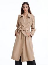a lady in a-lined camel trench coat with black pants